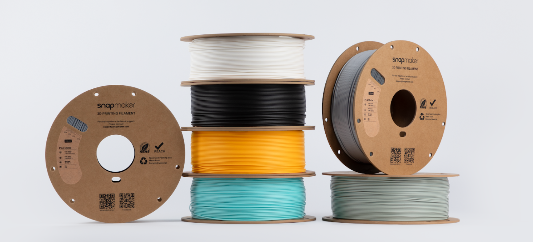 A close-up, studio shot of multiple spools of Matte PLA filament in various colors.